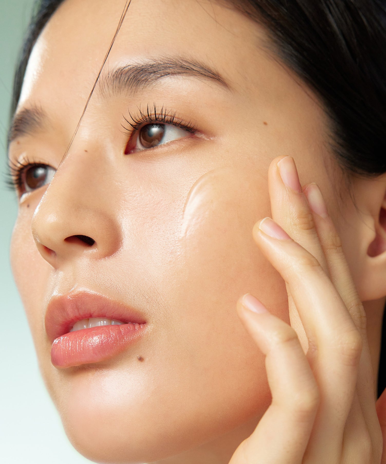 Décris l'image en français : visage avec peau hydratée, PURITO Wonder Releaf Centella Serum Unscented 60ml, marque PURITO, sérum.