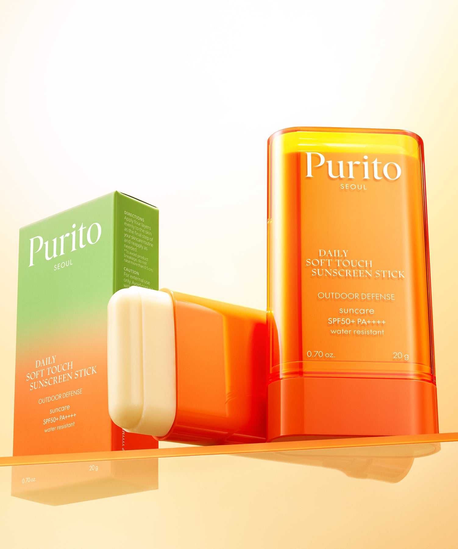 PURITO Daily Soft Touch Sun Stick SPF50+PA++++ protection solaire stick doux en boîte et ouvert sur fond lumineux orange.
