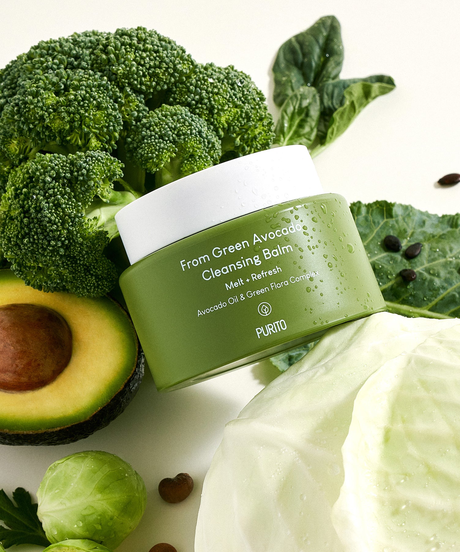 PURITO From Green Avocado Cleansing Balm 100ml posé parmi des légumes verts comme le chou, brocoli, avocat, indiquant une fraîcheur naturelle.