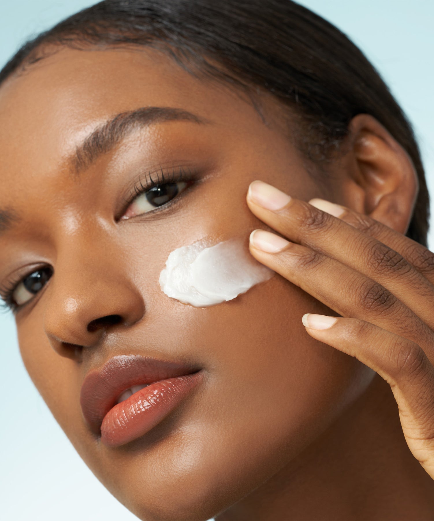 Femme appliquant PURITO From Green Avocado Cleansing Balm 100ml sur son visage, soin hydratant et nettoyant efficace pour la peau.