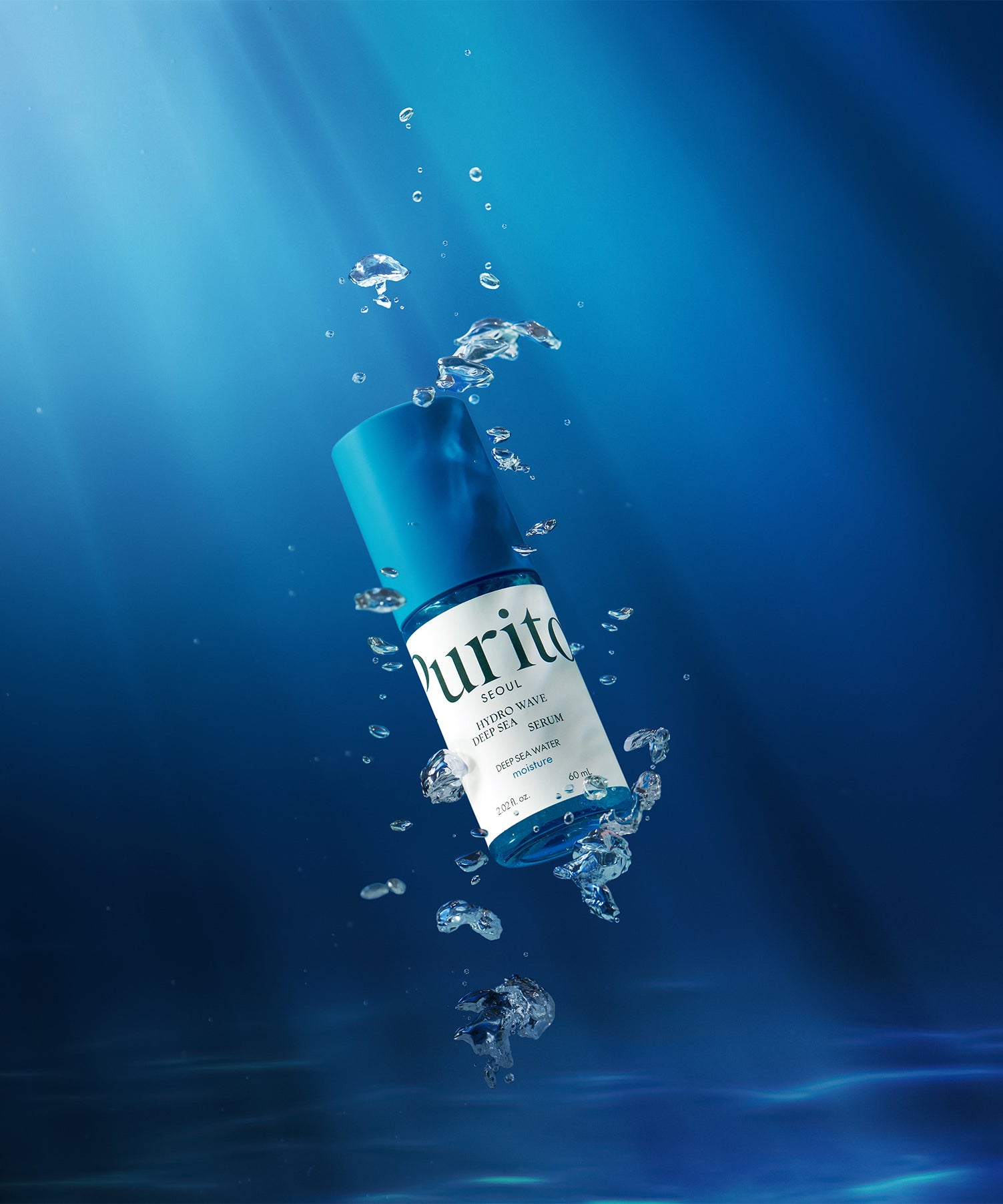 Flacon flottant de PURITO Hydro Wave Deep Sea Serum 60ml dans l'eau, avec bulles, fond marin bleu.