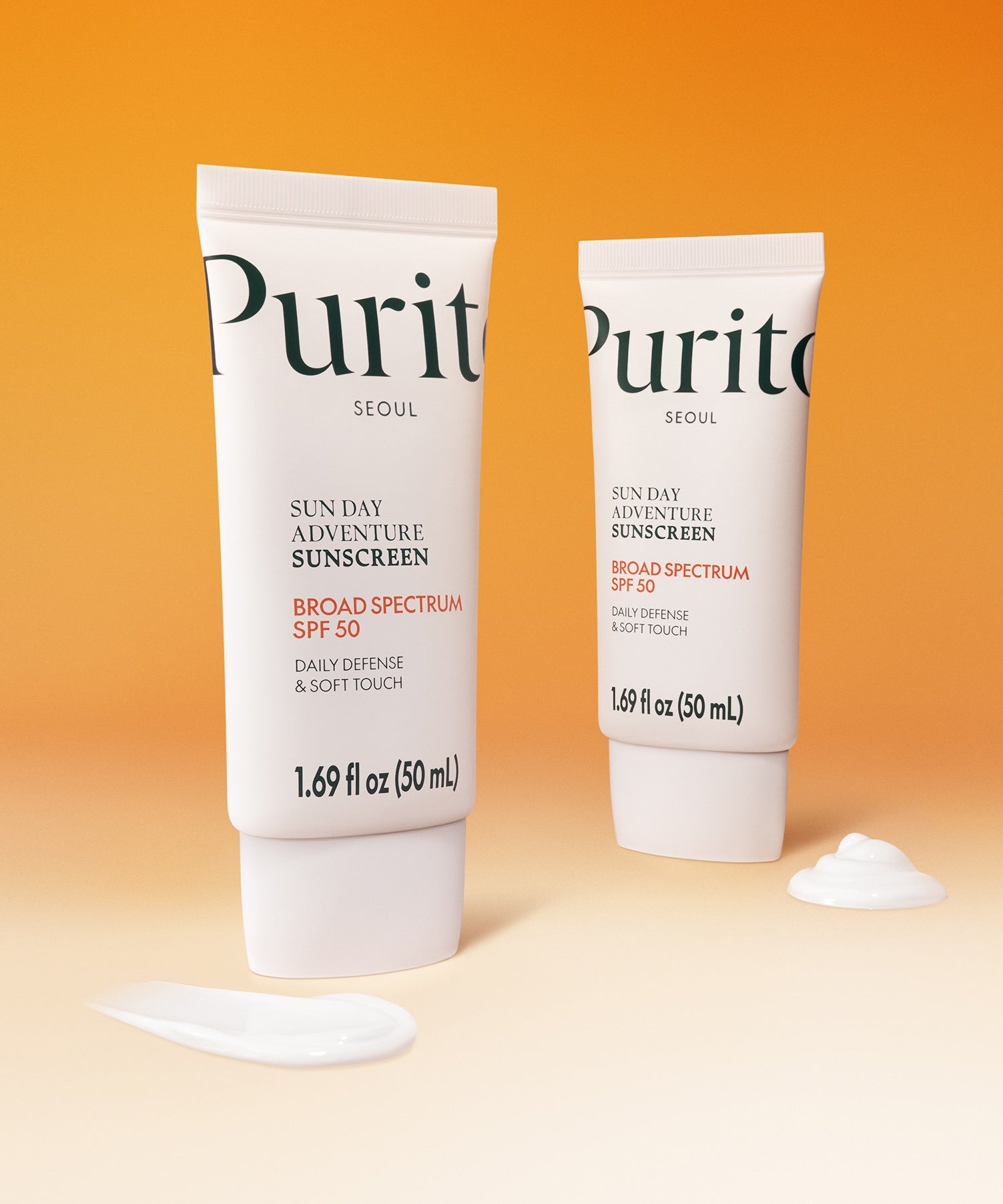 Deux tubes de PURITO Sunday Adventure Sunscreen SPF50 50ml sur fond orange, crème solaire quotidienne pour une protection efficace.