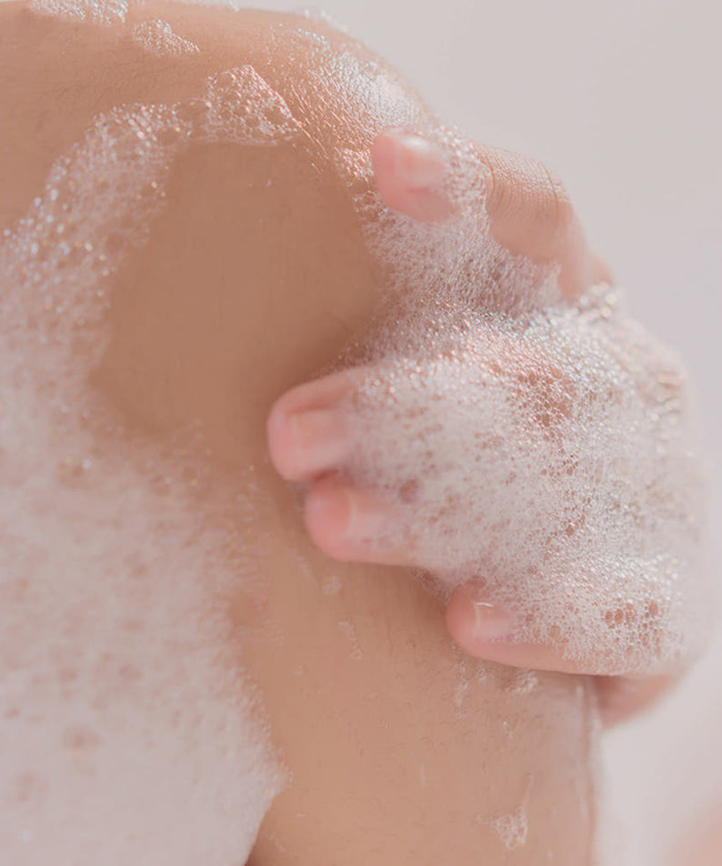 Enfant savonné utilisant PYUNKANG YUL Ato Mildly Acidic Moisturizing Body Wash 590ml, mousse douce sur la peau.