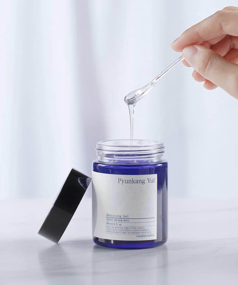 Gel PYUNKANG YUL Balancing 100ml en pot ouvert avec une main tenant une spatule, produit pour équilibrer la peau.
