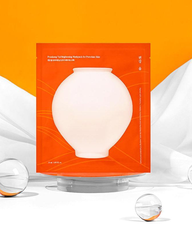 PYUNKANG YUL Brightening Porcelain Skin Mask Pack 10 pieces sur fond orange vibrant.