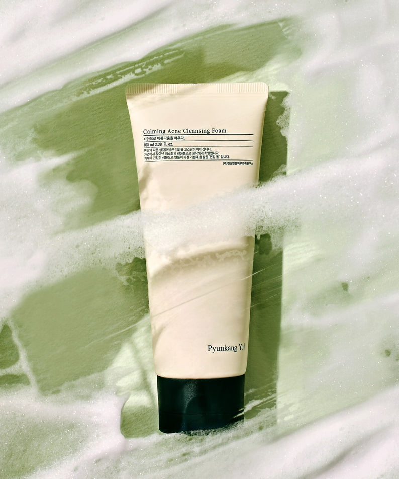 Nettoyant visage mousse PYUNKANG YUL Calming Acne Cleansing Foam 100ml sur fond de mousse apaisante verte.