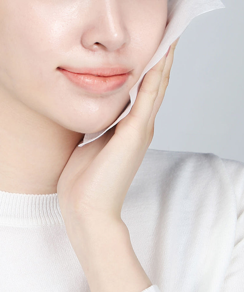 Femme utilisant PYUNKANG YUL Calming Face Towels 80 Pieces pour calmer et nettoyer la peau délicatement.