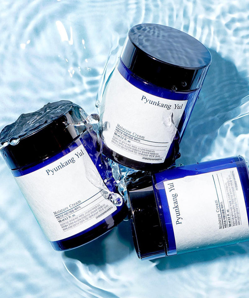 Crème hydratante PYUNKANG YUL Moisture Cream 100ml, trois pots sur fond aquatique, soin du visage hydratant et apaisant.