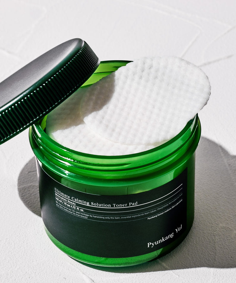Image des PYUNKANG YUL Ultimate Soothing Solution Toner Pads 70 sheets 140ml dans un pot vert ouvert.