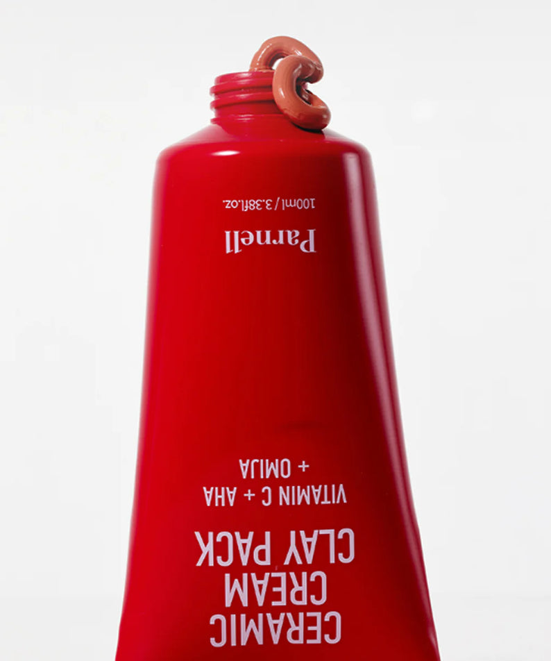 PARNELL  AHA Omija Ceramic Cream Clay Pack 100ml, crème argileuse en flacon rouge sur fond blanc, gros plan produit.