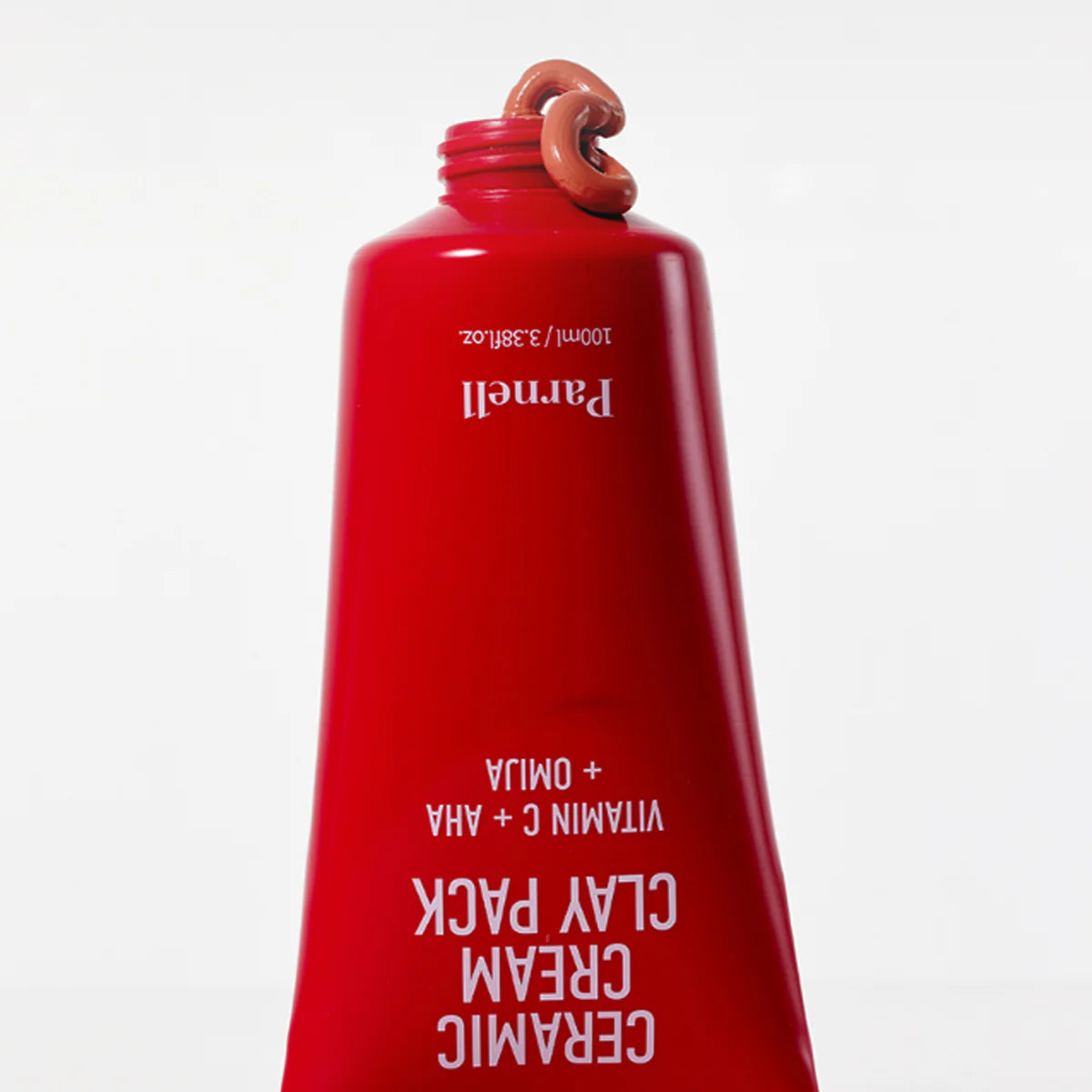 PARNELL  AHA Omija Ceramic Cream Clay Pack 100ml, crème argileuse en flacon rouge sur fond blanc, gros plan produit.