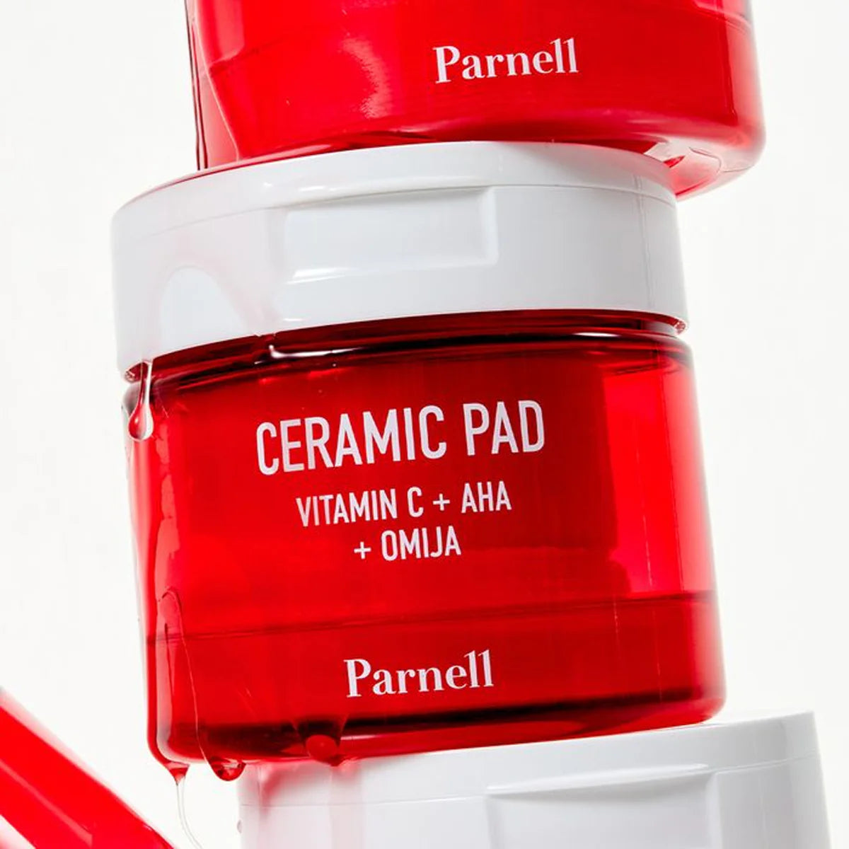 PARNELL  AHA Omija Ceramic Pad 60 Pads, flacon rouge Parnell sur fond blanc, pack « Ceramic Pad + Omija ».