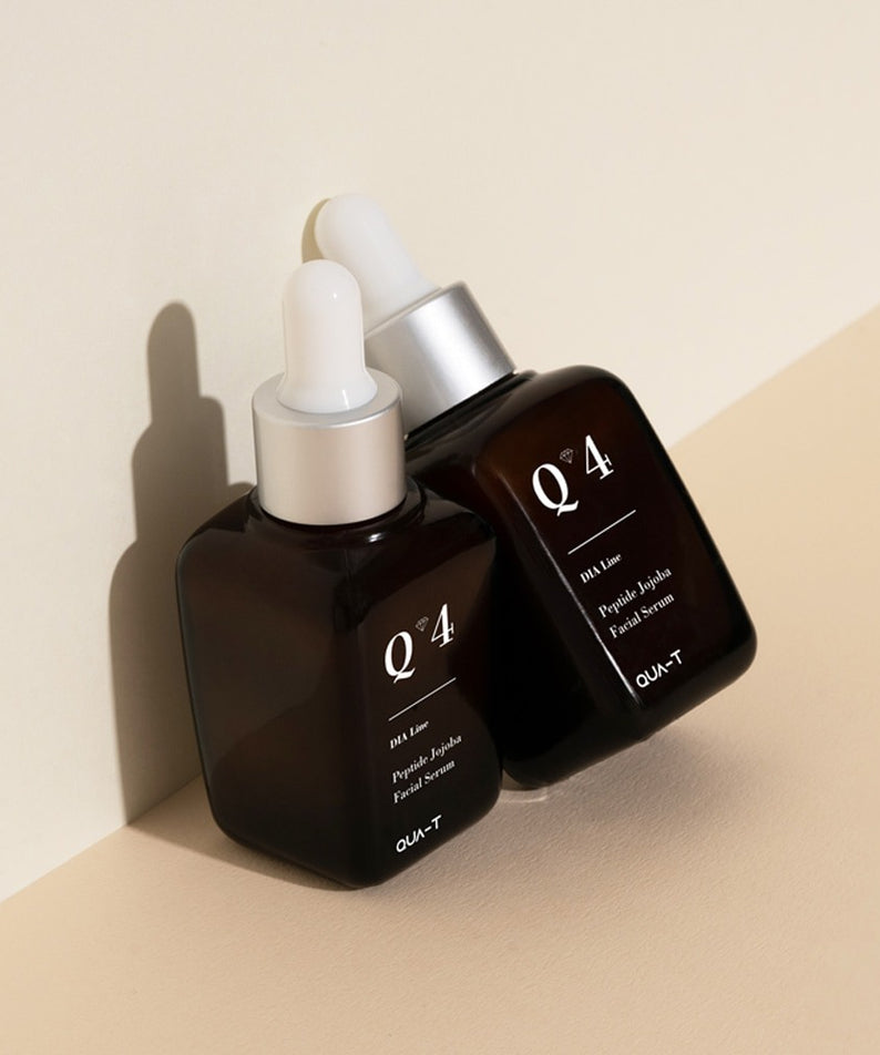 QUA-T Dia Peptide Jojoba Facial Serum 30ml par QUA-T, flacons sérum sur fond beige, contexte beauté cosmétique