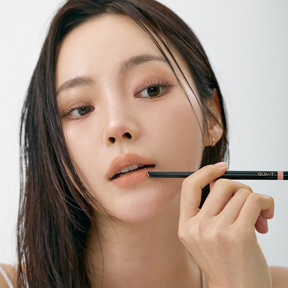 QUA-T NEW My Mood Lip Liner : femme maquille ses lèvres avec un crayon, fond studio lumineux, marque QUA-T.