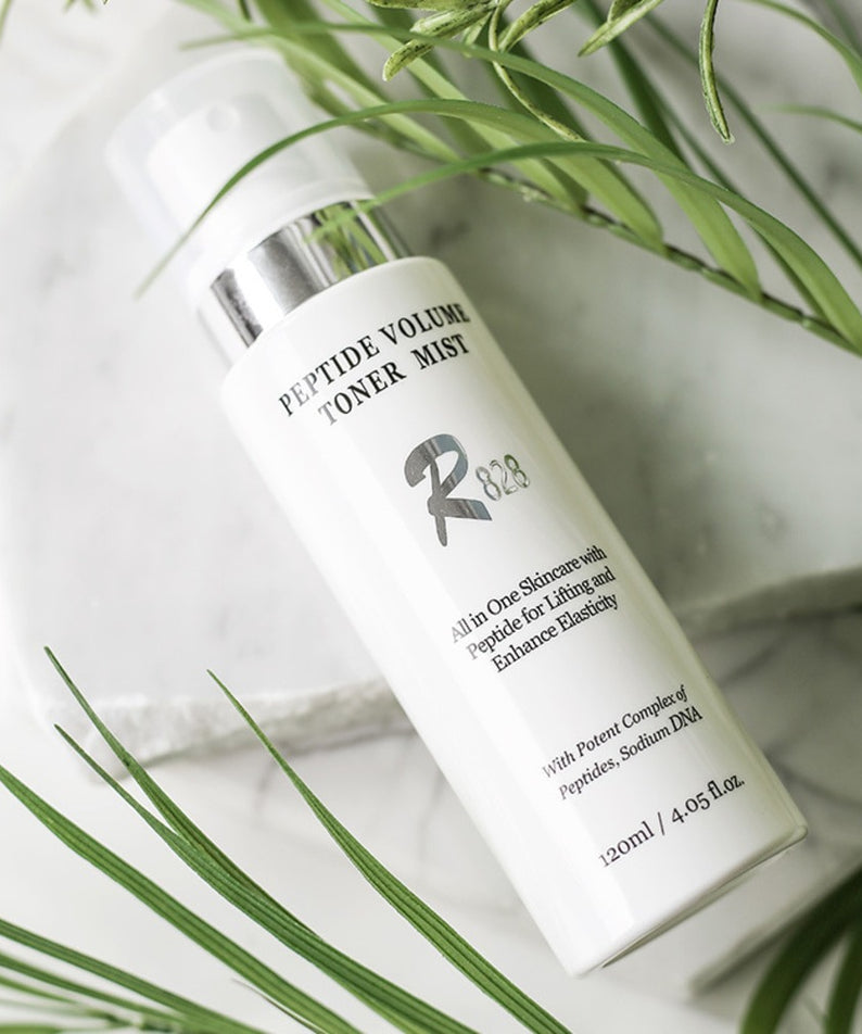 R828 Peptide Volume Toner Mist, flacon cosmétique éclairé avec herbes vertes; présentation skincare, marque Peptide Volume