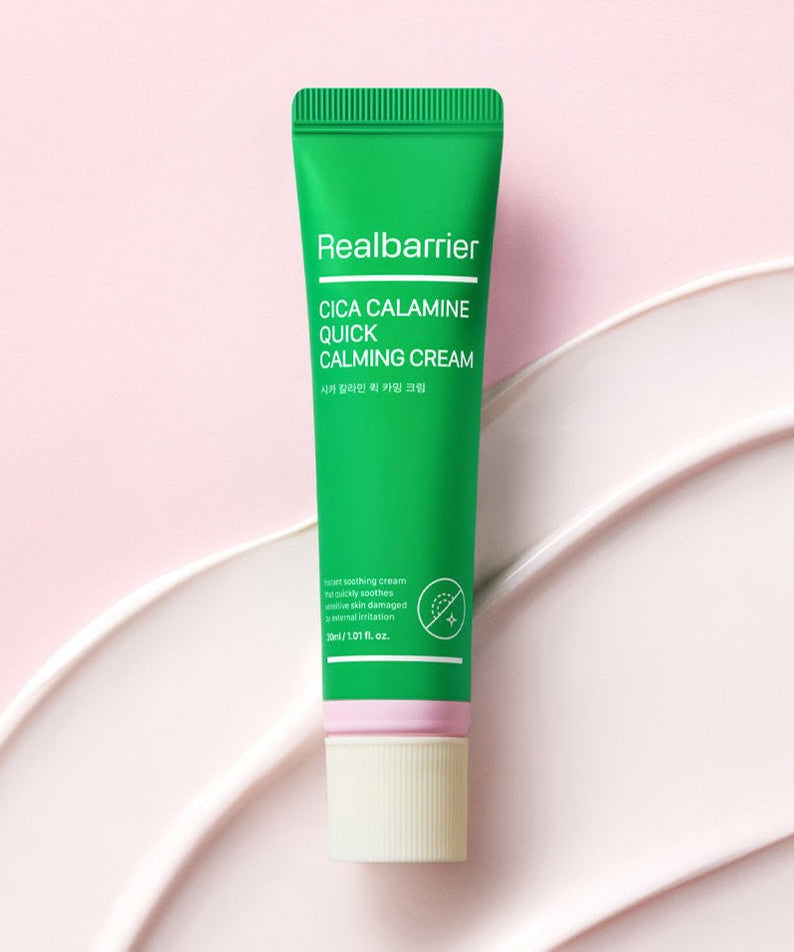 REAL BARRIER Cica Calamine Quick Calming Cream 30ml de Realbarrier, tube vert sur fond rose avec crème blanche.