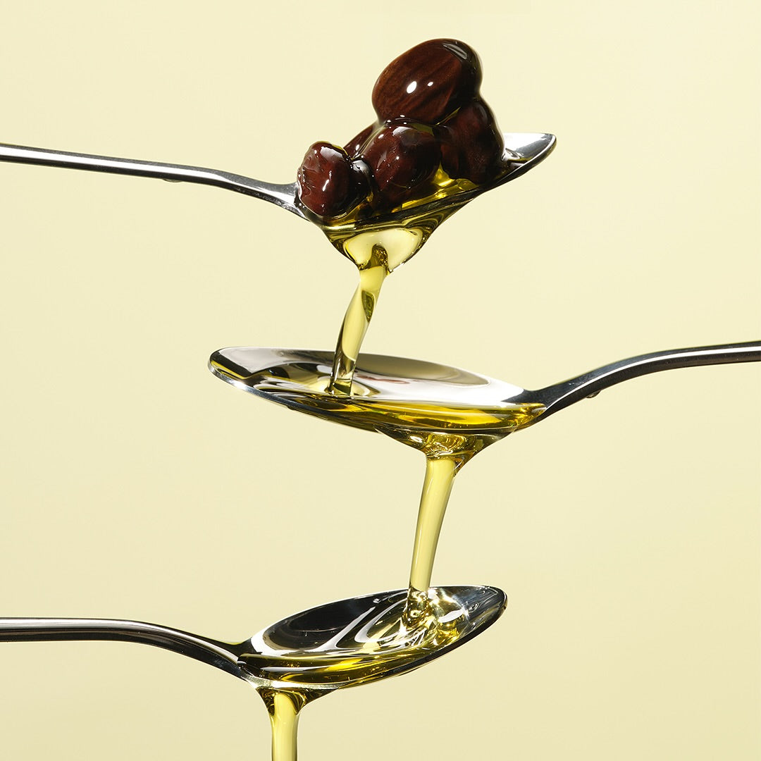 RETURNITY Organic Jojoba Oil 100% 50ml, huile biologique sur cuillère, marque visible en gouttes dorées sur fond clair.