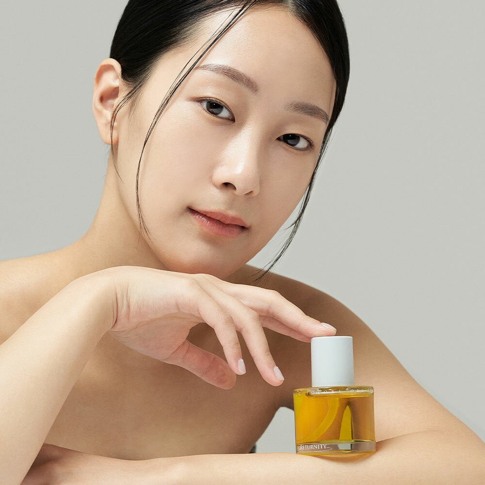 RETURNITY Organic Jojoba Oil 100% 50ml, pot cosmétique biologique près d’une femme en soin visage, ambiance beauté
