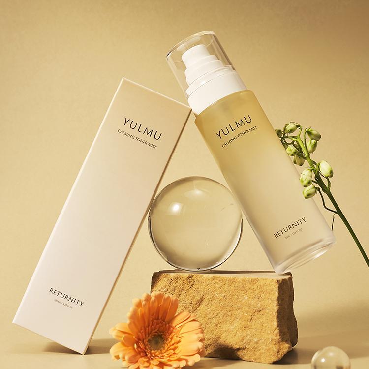 RETURNITY Yulmu Calming Toner Mist 100ml, brume apaisante de la marque RETURNITY, flacon sur fond beige avec fleurs et pierres
