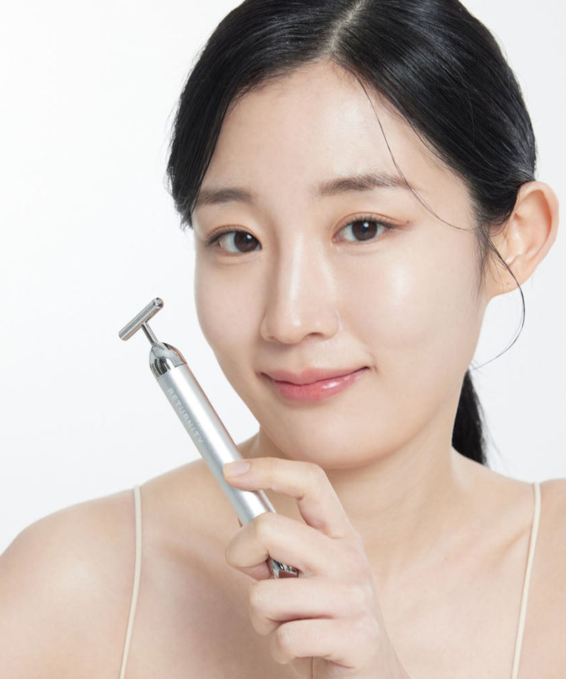 Femme souriante utilisant le RETURNITY Massage Booster Specail Offer en argent