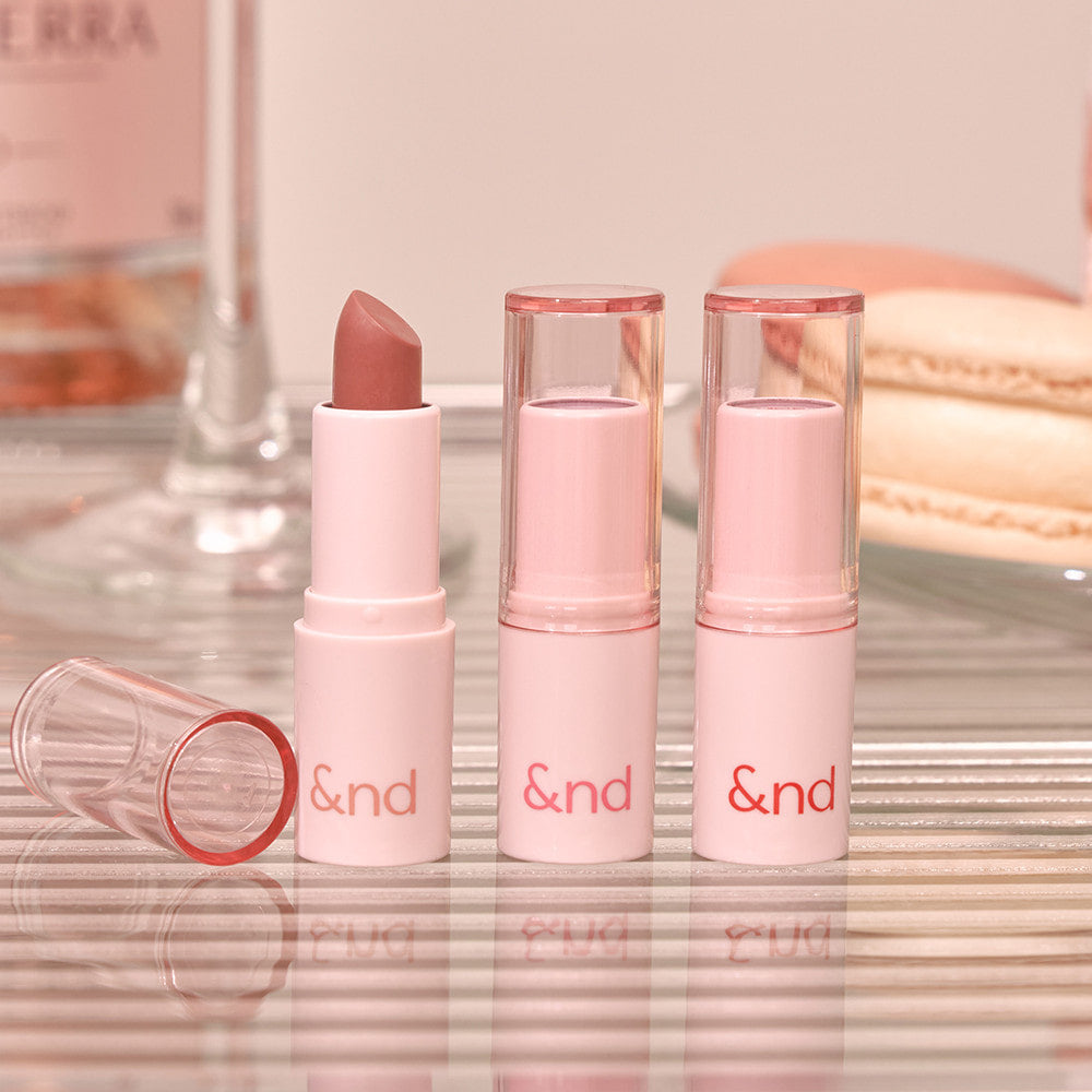 ROMAND  Glassy Bomb Balm, baume à lèvres rose & verres transparents sur fond maquillage doux, branding visible