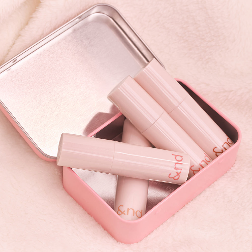 ROMAND  Glassy Bomb Tint, tube de gloss rose dans son étui, sur fond tissu, marque ROMAND, visuel beauté.