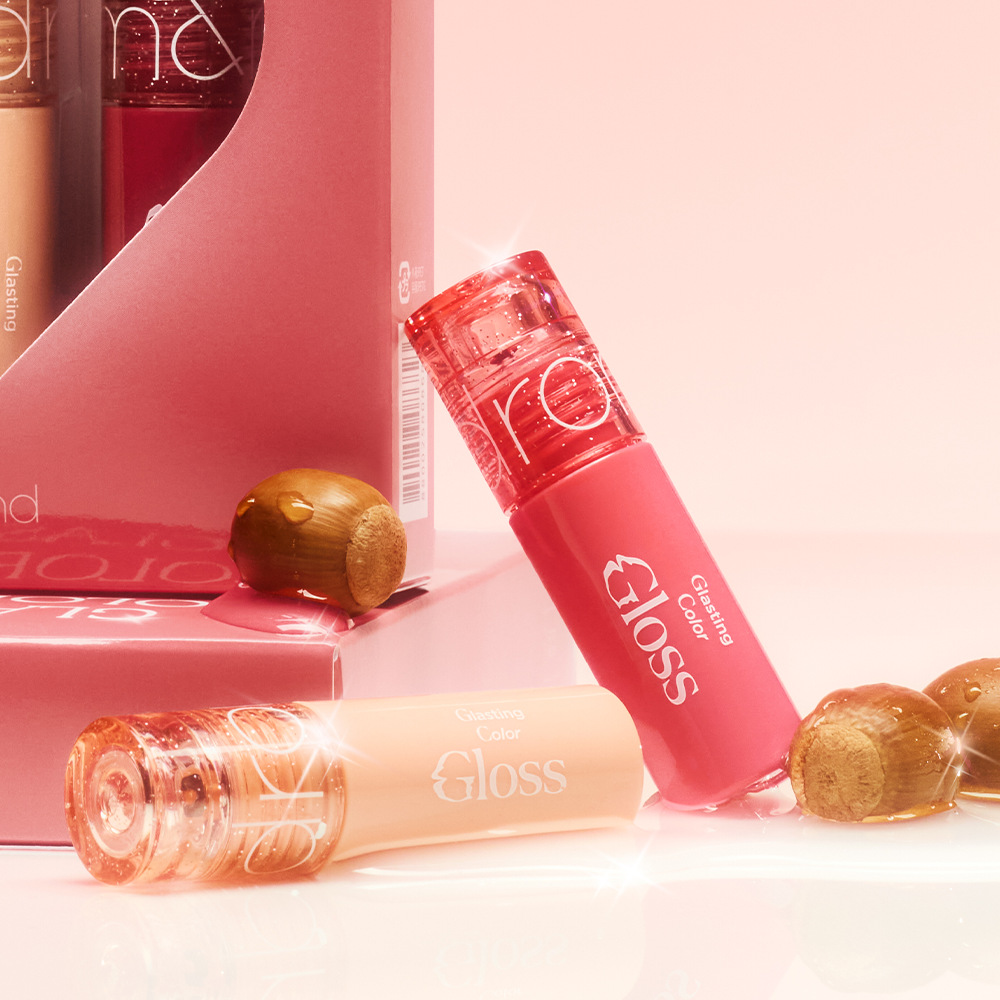 ROMAND MINI Glasting Color Gloss de la marque ROMAND, tube rouge glossy sur fond rose, éclats et noisettes en décor