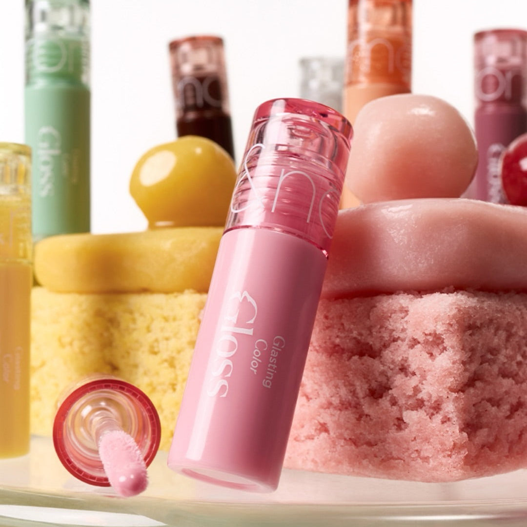 ROMAND MINI Glasting Color Gloss, gloss rose en vitrine avec produits de beauté et flacons colorés en arrière-plan