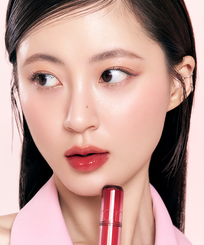 ROMAND The Juicy Lasting Tint rouge à lèvres brillant, maquillage élégant sur fond rose, visage féminin avec produit cosmétique ROMAND.