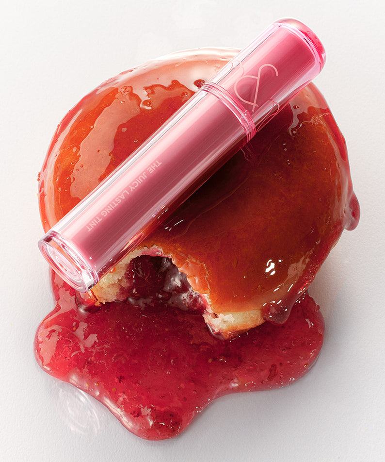 ROMAND The Juicy Lasting Tint sur un fond de gelée rouge vif, parfait pour des lèvres éclatantes et durables. Idéal pour une touche de couleur fruitée.