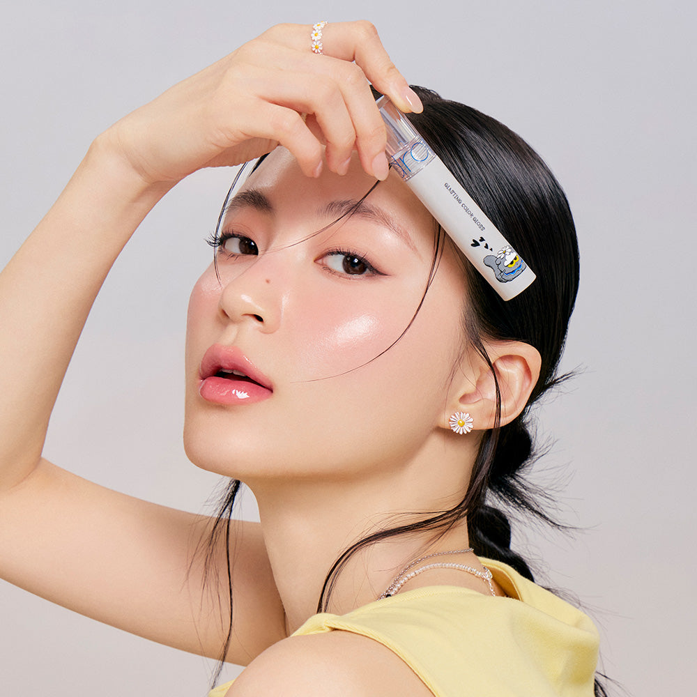 ROMAND x Joanne Friends Glasting Color Gloss : tube cosmétique sur peau et maquillage glossy, photo beauté sur fond clair.