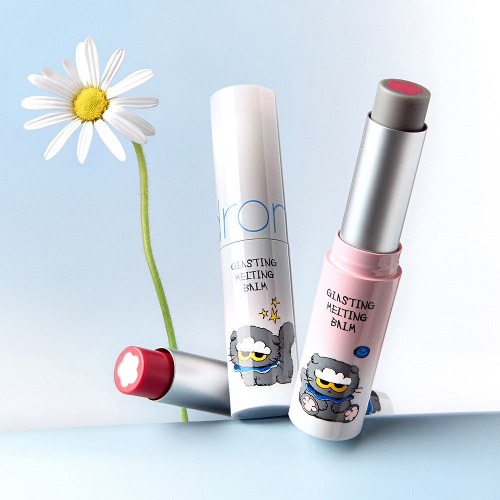 ROMAND x Joanne Friends Glasting Melting Balm, pack et baume sur fond bleu avec fleur, produits maquillage de la marque