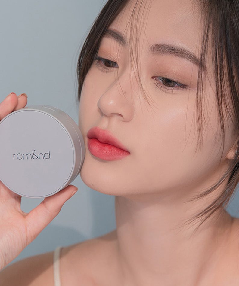 Femme appliquant ROMAND zero cushion pour un teint parfait et naturel.