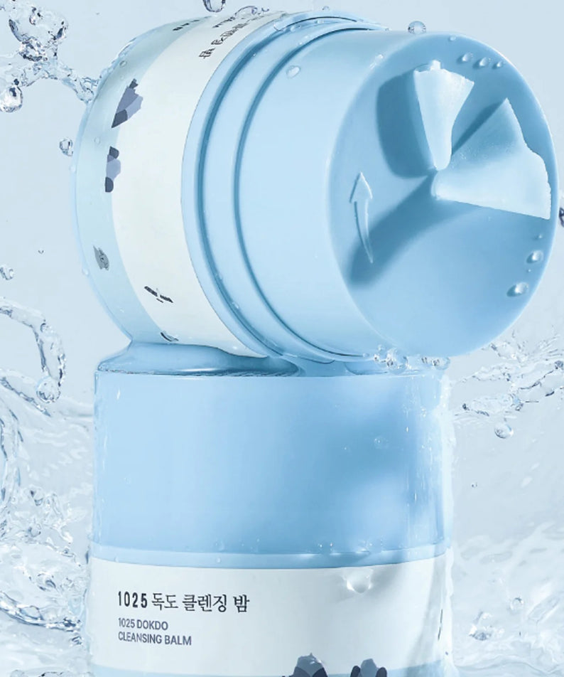 ROUND LAB 1025 Dokdo Cleansing Balm 50ml de Round Lab, baume nettoyant dans un contexte aquatique bleu, gouttes d’eau.