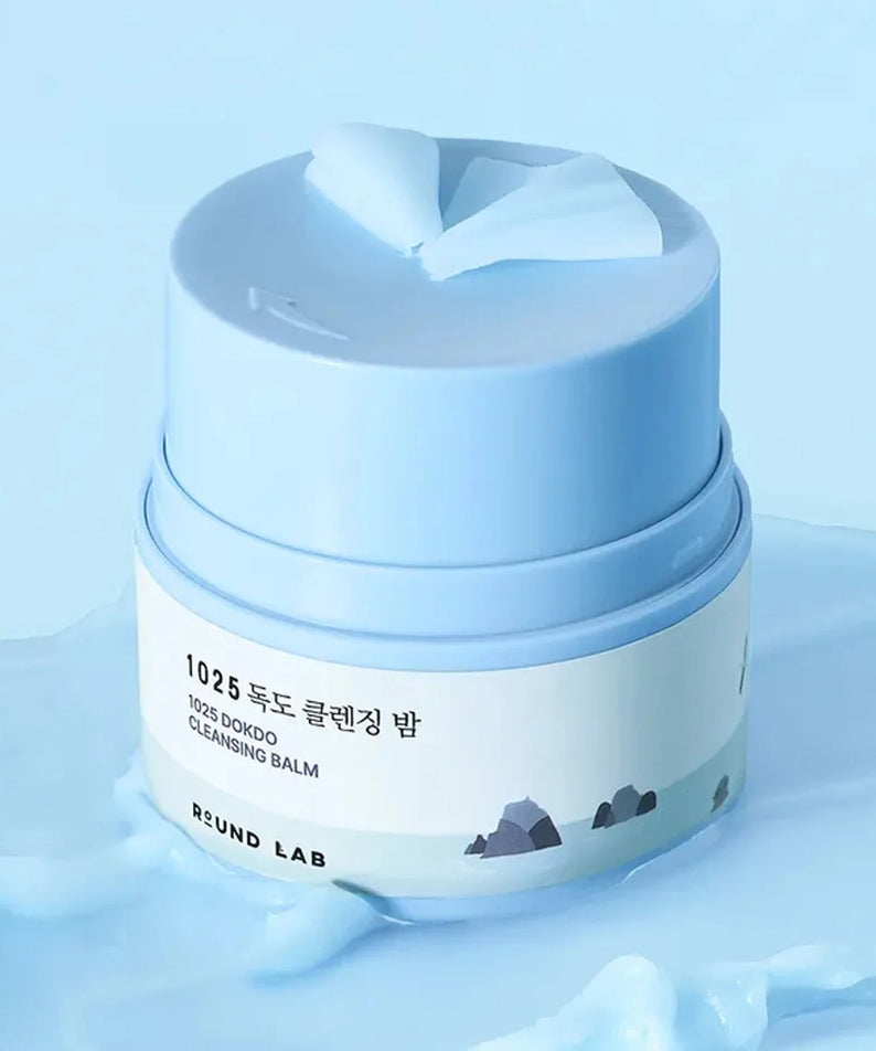 ROUND LAB 1025 Dokdo Cleansing Balm 50ml de ROUND LAB sur fond bleu, baume nettoyant en contexte spa.