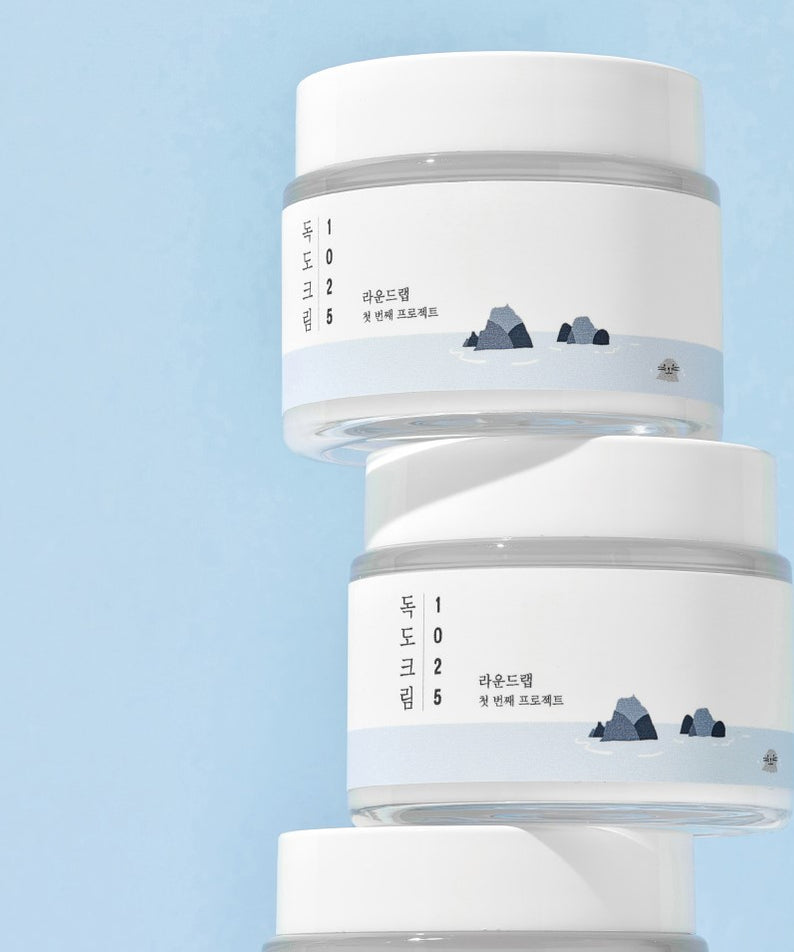 Pot de ROUND LAB 1025 Dokdo Cream 80ml sur fond bleu, soin populaire pour la peau en Corée.