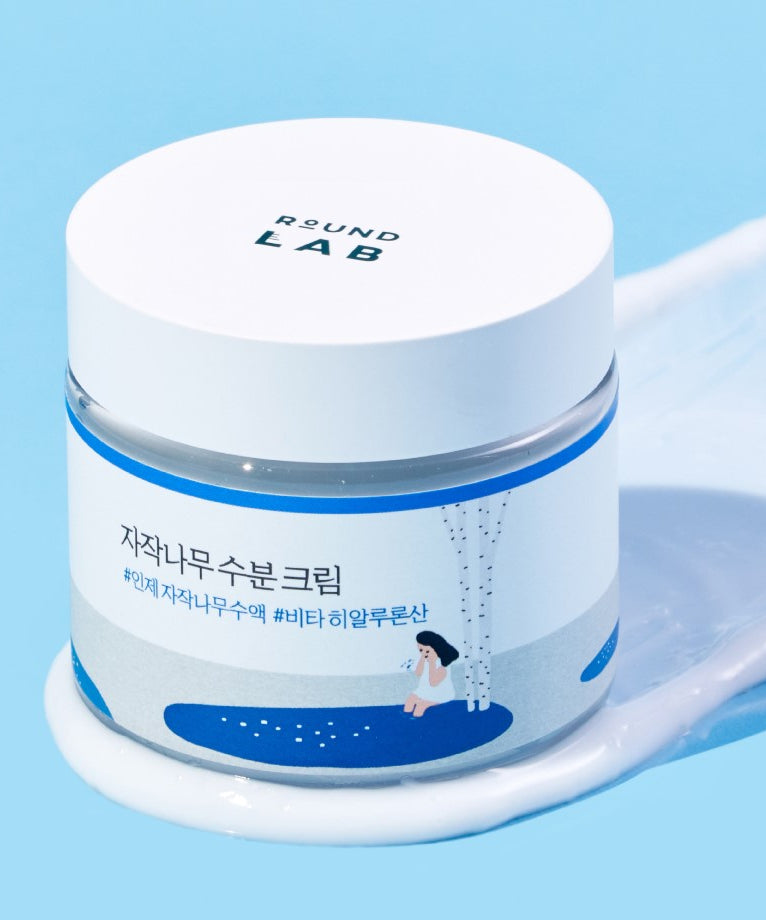 Pot de ROUND LAB Birch Juice Moisturizing Cream 80ml sur fond bleu vif.