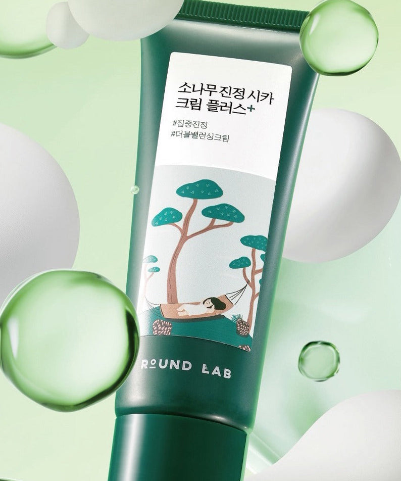 ROUND LAB  Pine Calming Cica Cream Plus 60ml : crème apaisante Cica, tube vert sur fond vert avec bulles et feuilles.