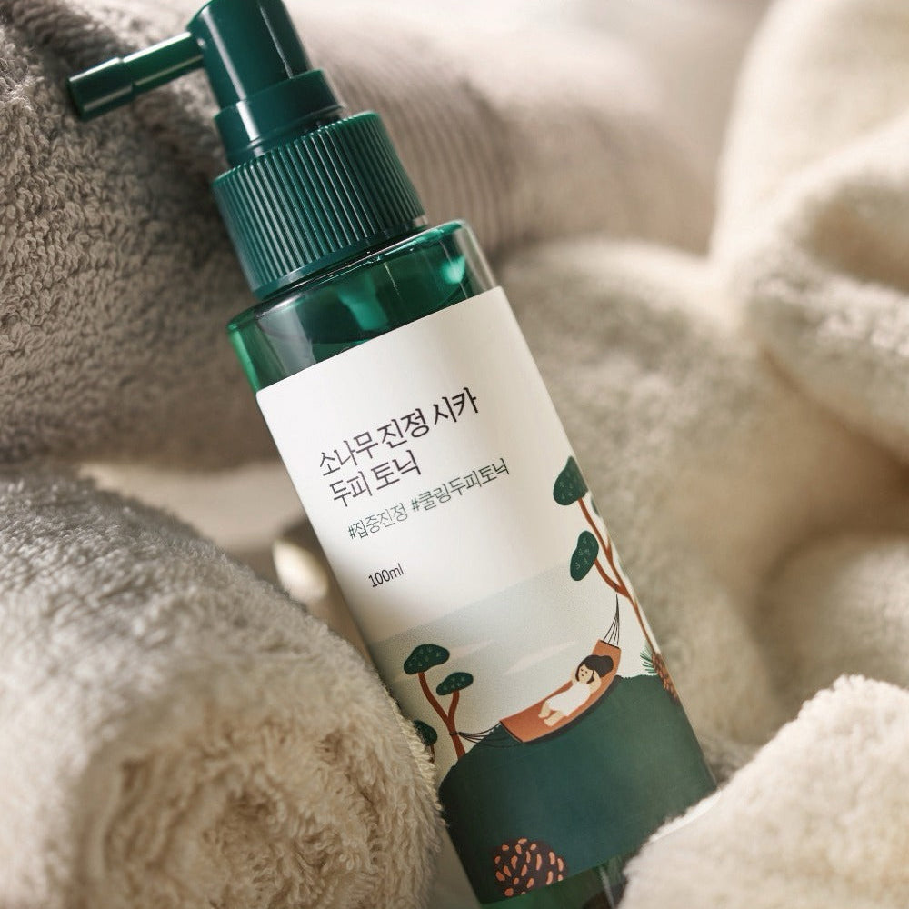 ROUND LAB  Pine Calming Cica Hair Tonic 100ml sur serviette douce, marque ROUND LAB, contexte spa à la maison