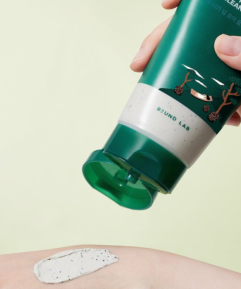 ROUND LAB Pine Cica Deep Pore Clay Pack Cleanser 150ml, tube vert tenu, argile blanche sur peau, décor jaune clair.