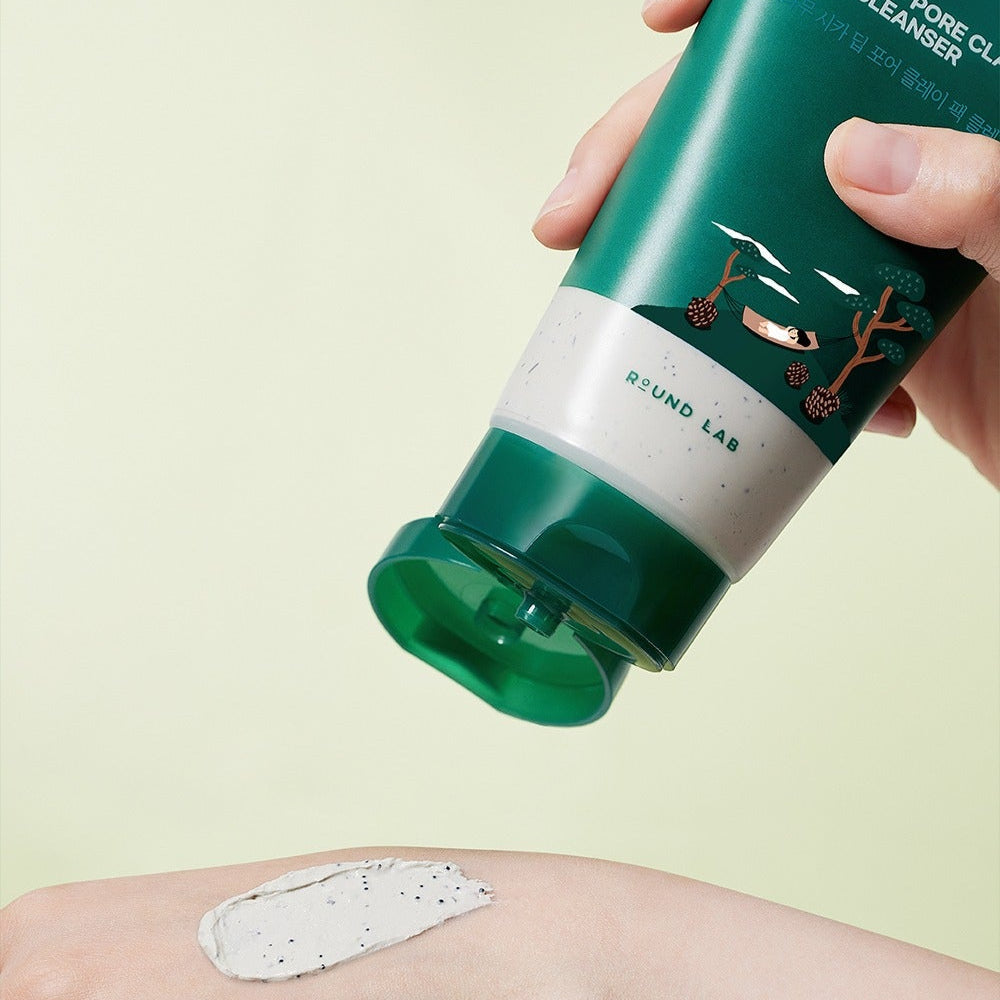 ROUND LAB Pine Cica Deep Pore Clay Pack Cleanser 150ml, tube vert tenu, argile blanche sur peau, décor jaune clair.