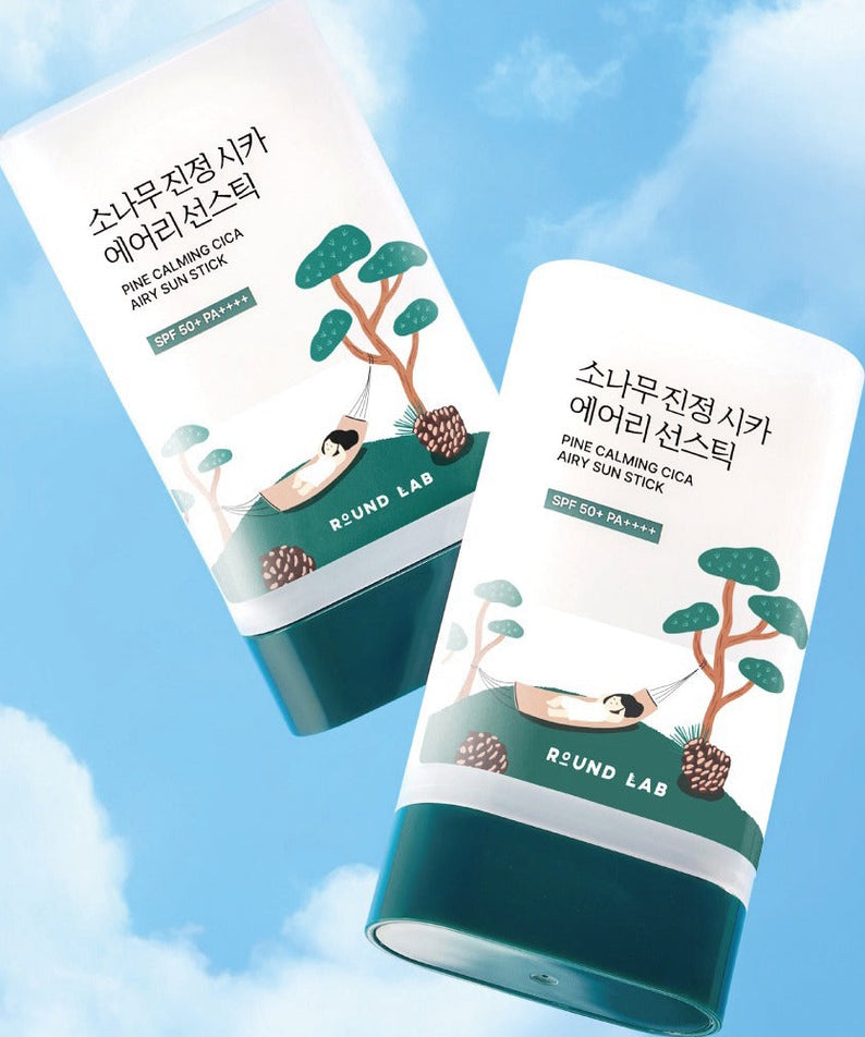 ROUND LAB Pine Soothing Cica Airy Sun Stick 19g, marque ROUND LAB, tubes solaires contre ciel bleu, avec illustrations cica/pin