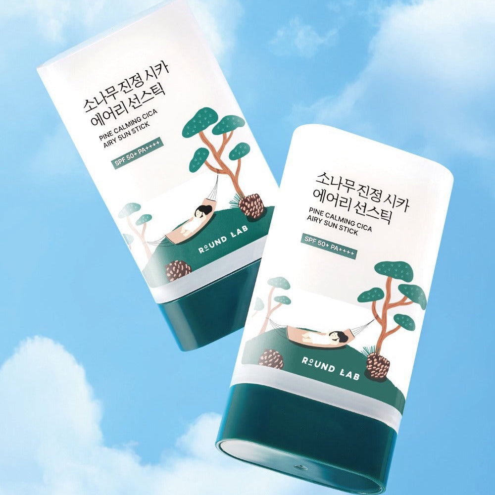 ROUND LAB Pine Soothing Cica Airy Sun Stick 19g, marque ROUND LAB, tubes solaires contre ciel bleu, avec illustrations cica/pin