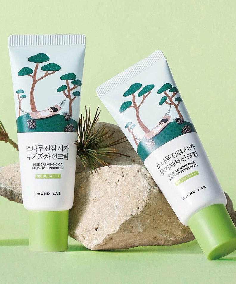 ROUND LAB Pine Tree Calming Cica Mineral Sunscreen 40ml, tubes sur fond vert avec pierres et végétation, marque ROUND LAB