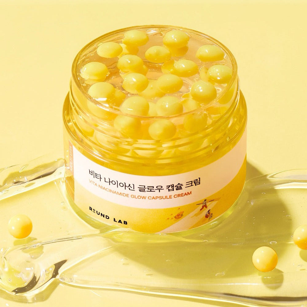 ROUND LAB  Vita Niacin Glow Capsule Cream 50ml, pot crème jaune avec capsules, sur fond lumineux jaune, marque présentée
