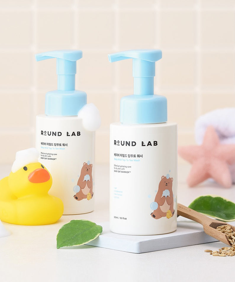 Produits de bain pour bébé avec ROUND LAB Baby Mild Top To Toe Wash 300ml, décorés avec jouet de canard et accessoires de bain.