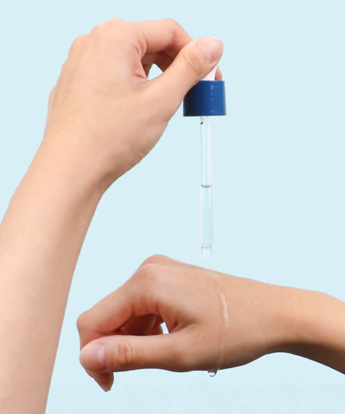 Application du ROUND LAB Birch Moisture Ampoule 50ml sur la peau avec une pipette pour l'hydratation.