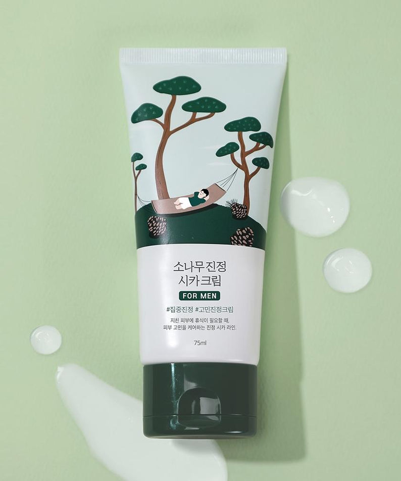 ROUND LAB For Men Pine Calming Cica Cream 75ml, tube crème sur fond vert avec motifs cica, contexte visuel spa.