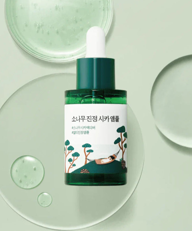 Ampoule ROUND LAB Pine Calming Cica 30ml sur fond vert, soin apaisant.