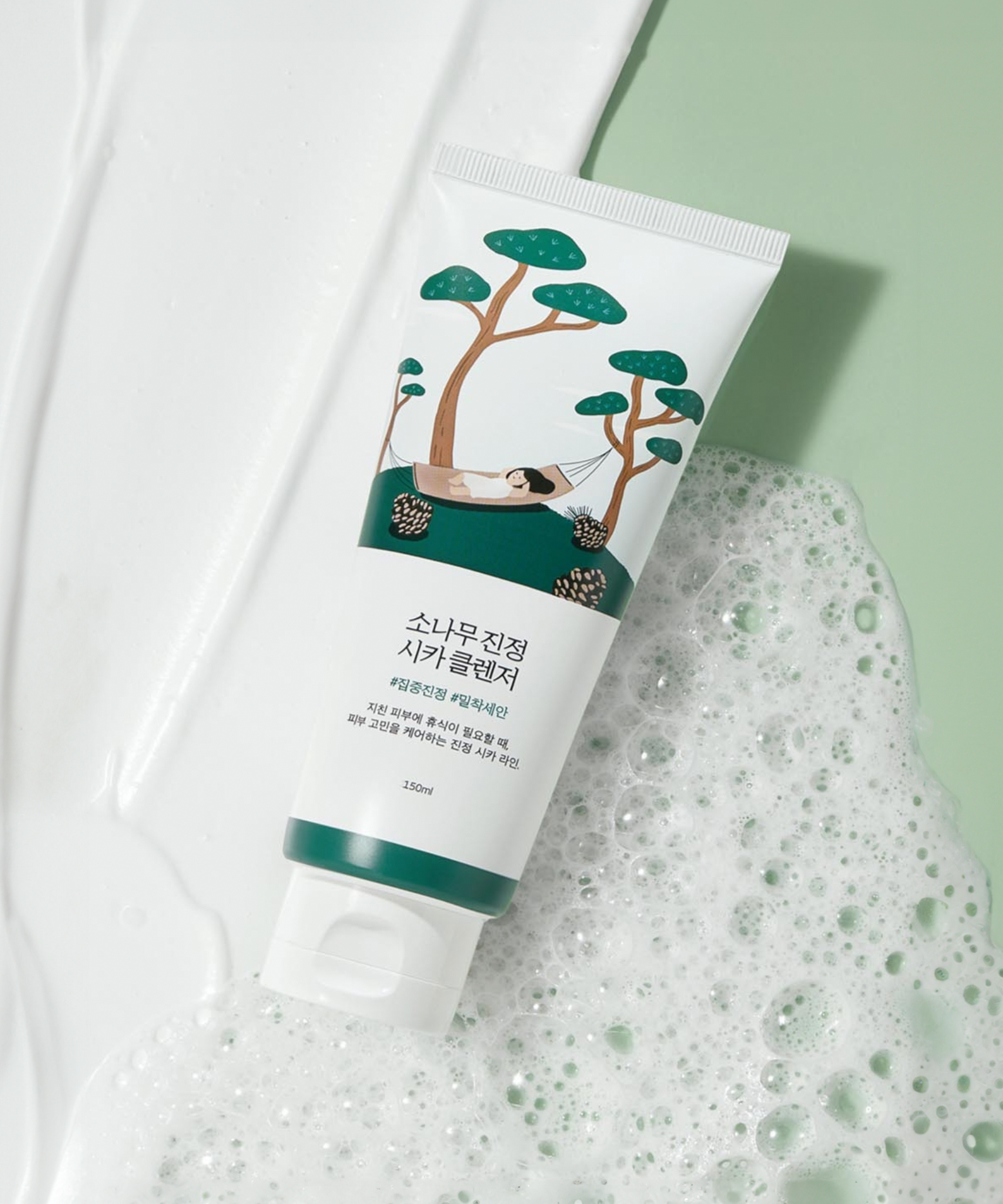 ROUND LAB Pine Calming Cica Cleanser 150ml sur fond de mousse blanche et verte.